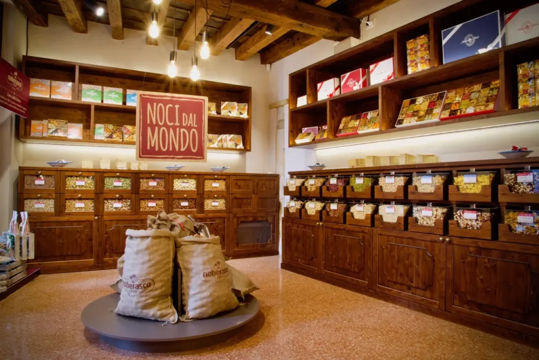 Allestimento negozio di frutta, verdura e frutta secca con espositori ordinati e colorati, studiati per valorizzare i prodotti freschi e secchi, creando un ambiente accogliente e funzionale, ideale per attrarre i clienti e facilitare la spesa